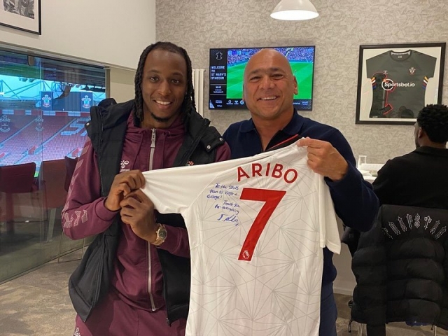 Prem footballer Joe Aribo with Kingston College football academy coach Mark Fabian, holding Joe's signed shirt